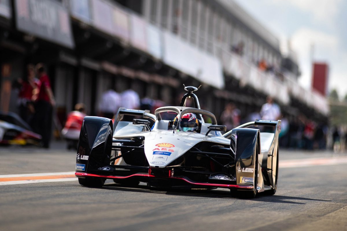 Nissan Formula E Racer accelerates out of pit area front view